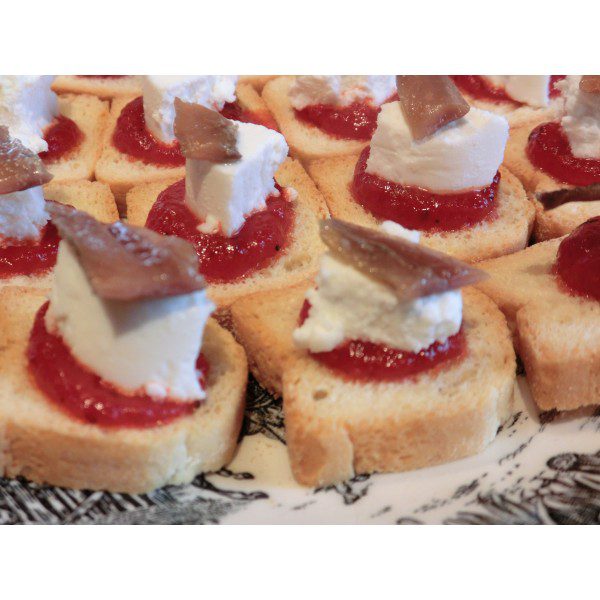 Small toast with roasted red pepper jam, goat cheese and anchovy